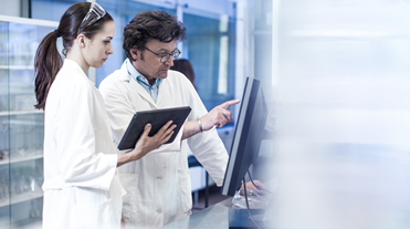 People in labcoats at work in lab